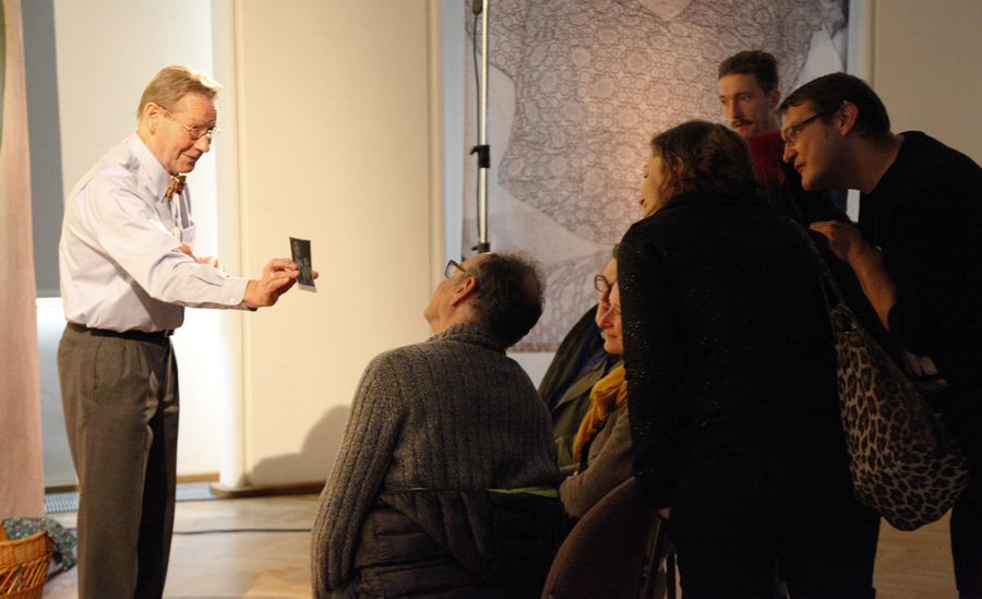 Ein Mann zeigt einer Gruppe ein Foto.