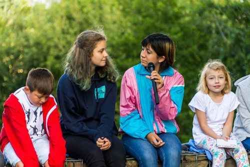 4 Kinder sitzen auf einer Mauer
