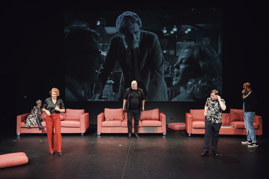 Vier Personen vor 3 roten Sofas