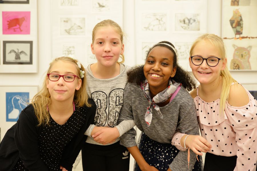 Vier Mädchen vor Bildern