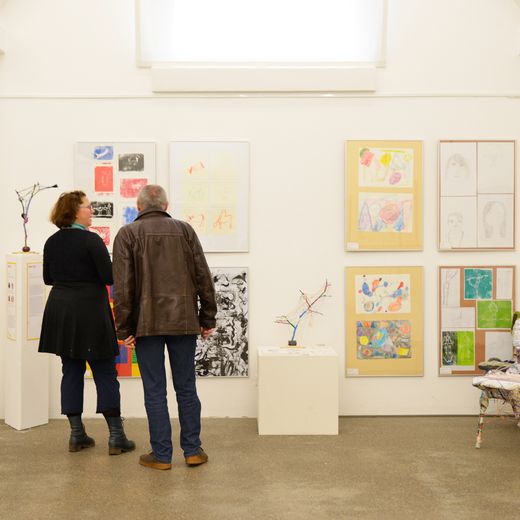 Zwei Personen in einer Kunstausstellung von Schülern