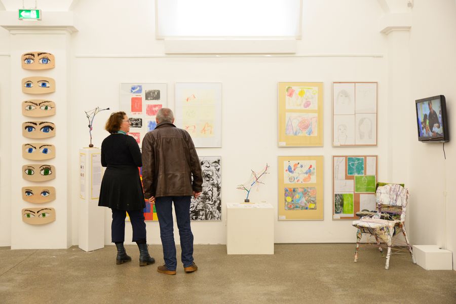 Zwei Personen in einer Kunstausstellung von Schülern