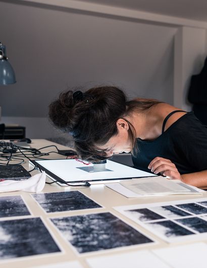 Frau betrachtet Negativ mit Lupe