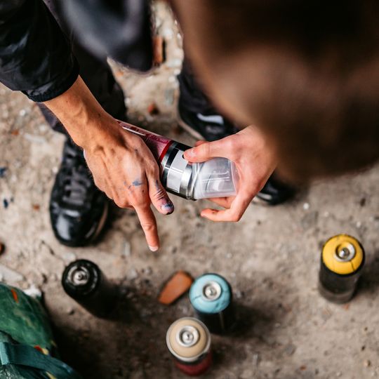 Person über Sprayflaschen gebeugt