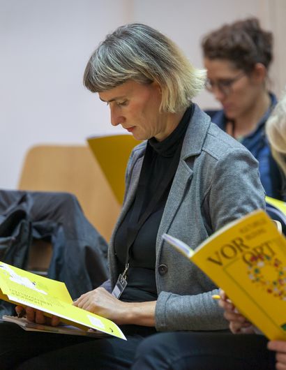 Personen lesen eine Broschüre 