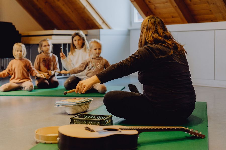 Frau die mit Kinder auf dem Boden sitzt