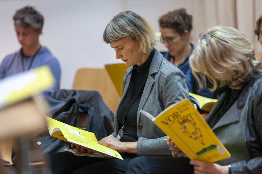 Personen schauen sich ein Broschüre an
