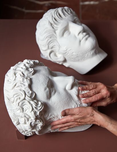 Foto von zwei Büsten. Eine Büste wird von Händen umformt.