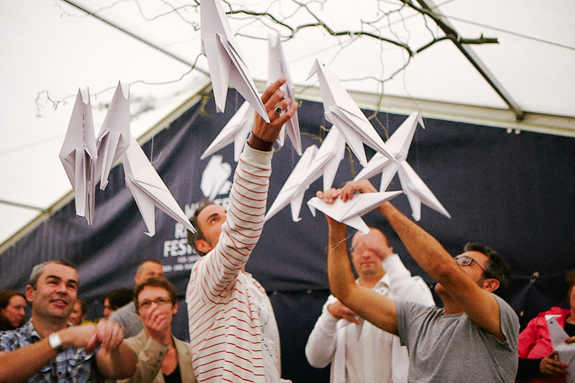 Menschengruppe mit Origami-Vögeln