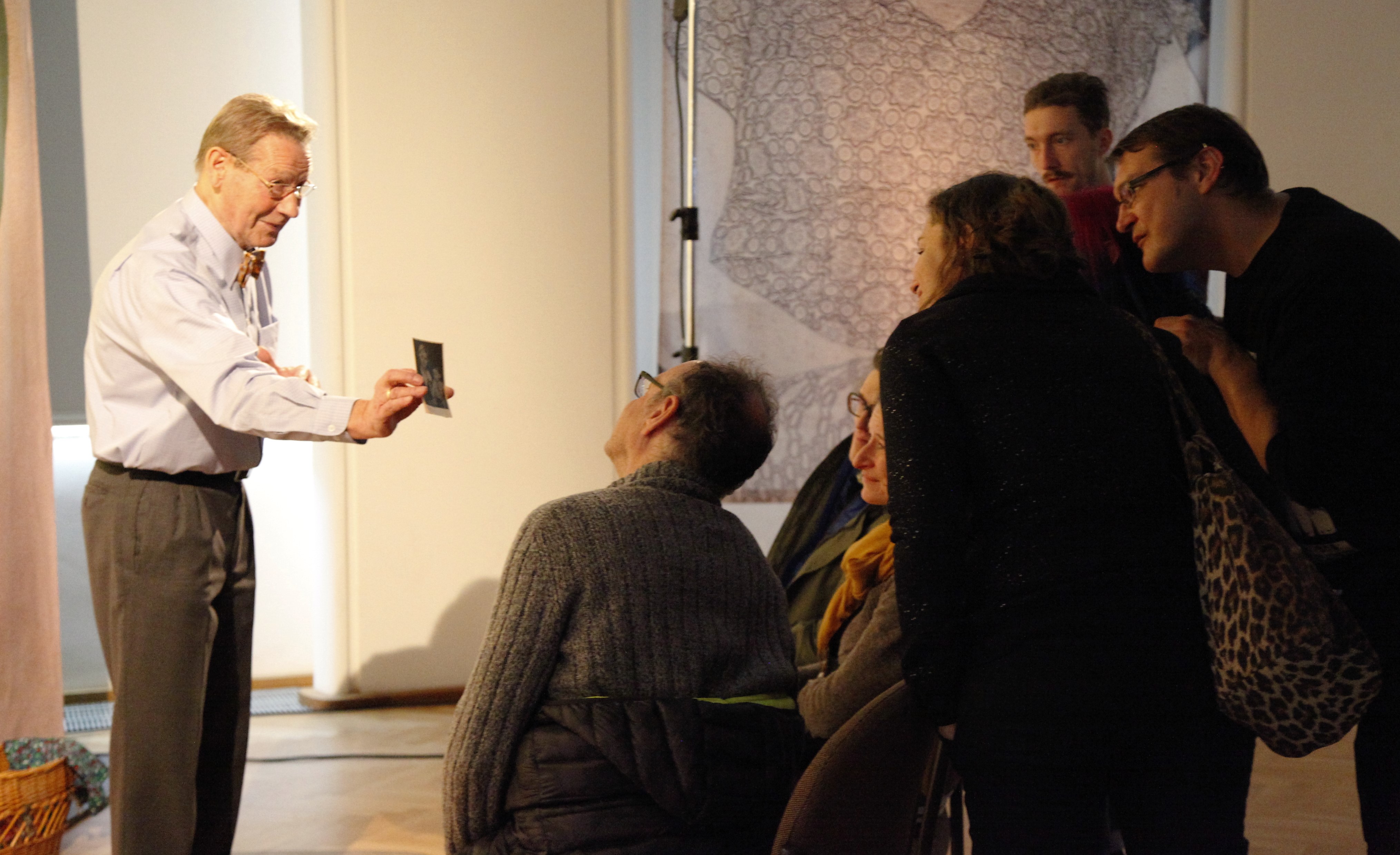 Ein Mann zeigt einer Gruppe ein Foto.