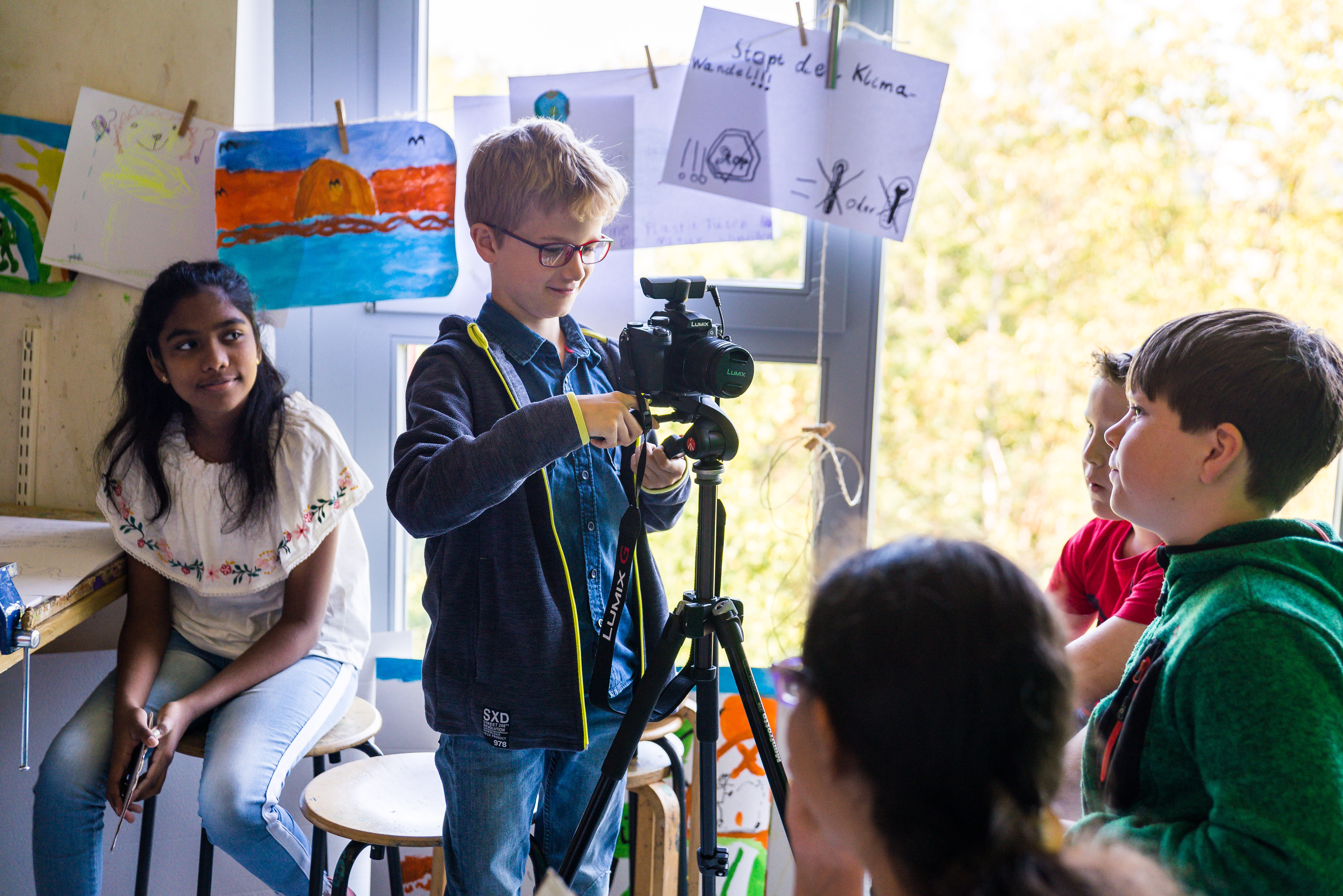 Kind mit Kamera auf Stativ